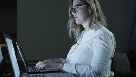 Focused-businesswoman-in-eyeglasses-using-laptop